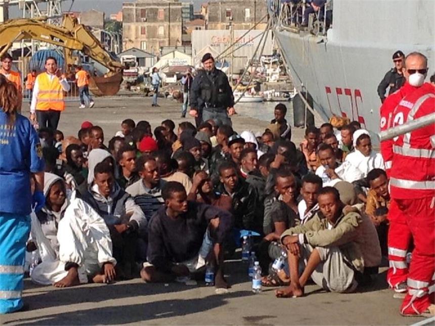 Schulz in Rom: EU muss in Flüchtlingskrise solidarisch sein Eine Gruppe von Flüchtlingen wartet im Hafen von Catania, Sizilien (Italien), nachdem sie ein italienisches Marineschiff verlassen haben, das sie gerettet hat. Foto: Maurizio D'arro/Archiv