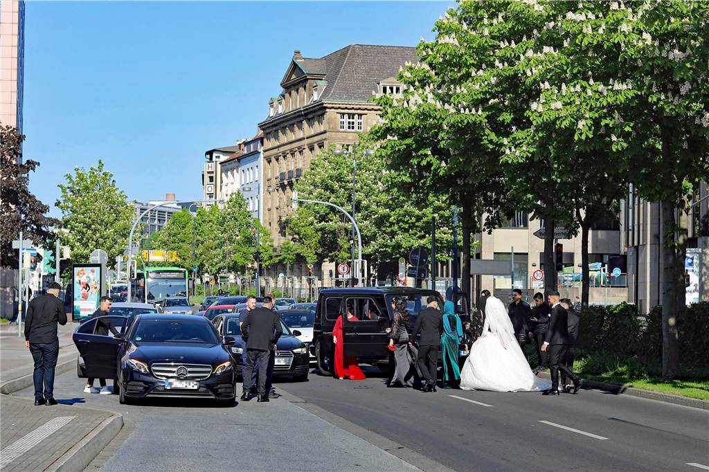 Dortmunder Professor: Bei Straßen-Blockade geht es um Provokation Mehrere Autos blockieren die Fahrbahn des Wall in Dortmund. Eine Frau in weißem Brautkleid und mehrere junge Männer in Anzügen sind zu sehen.