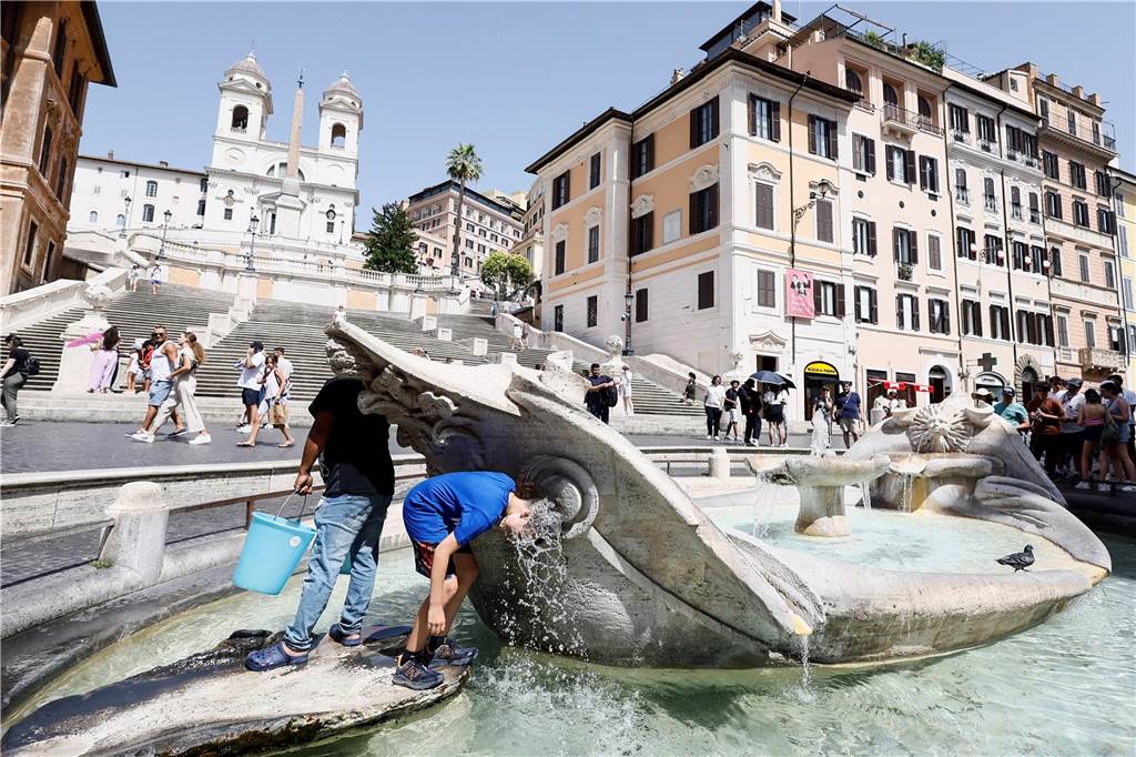 Hitzealarm in Italien und Spanien: Alarmstufe rot in Urlaubsregionen ausgerufen Eine Junge kühlt sich in der Fontana della Barcaccia vor der Spanischen Treppe in Rom ab