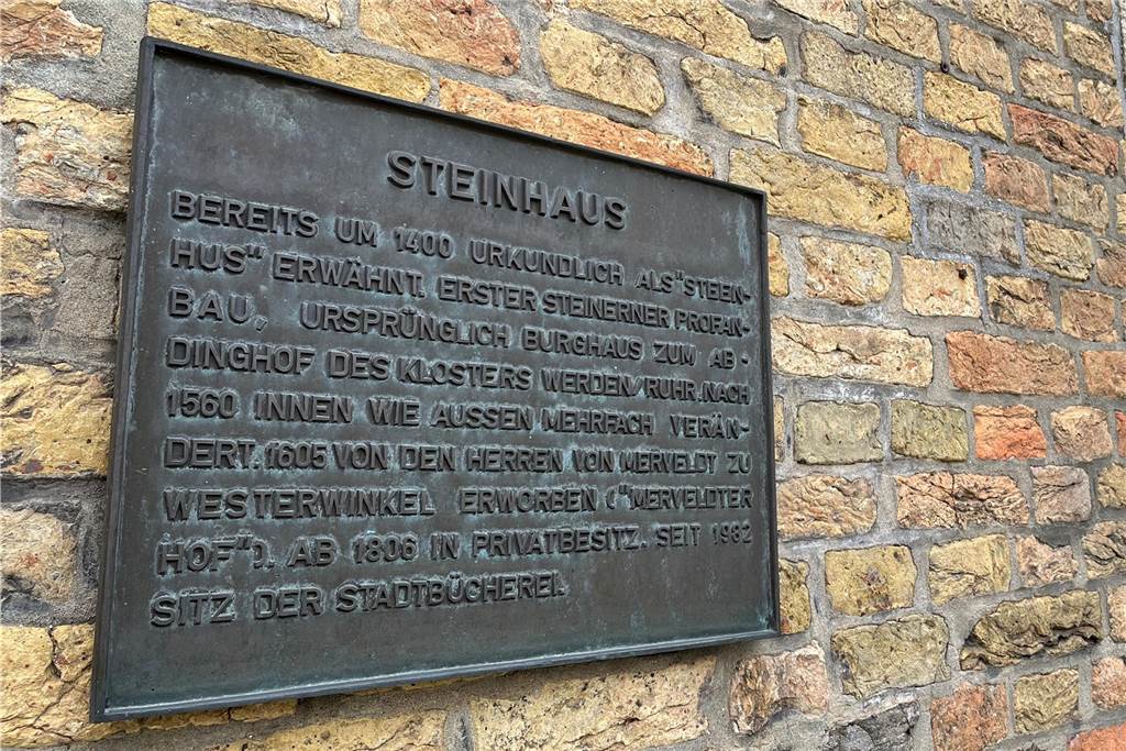Das Steinhaus: Ein repräsentativer Bau für die Verwaltung des Klosterbesitzes Werden Eine kleine Tafel informiert in Kurzform über die Geschichte des Gebäudes.