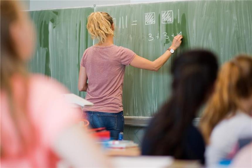 Referendariat für angehende Lehrer künftig auch in Teilzeit Eine Lehrerin schreibt an eine Schultafel. Foto: Julian Stratenschulte/Archiv