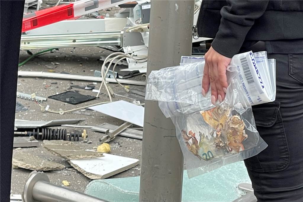 Video: Geldautomat gesprengt – unter den Trümmern liegen noch Scheine Eine Mitarbeiterin eines Security-Dienstes sammelte beschädigte Geldscheine, die die Arbeiter zwischen dem Schutt gefunden hatten.