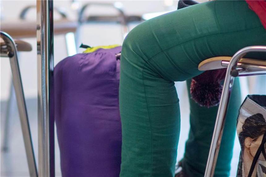 Zahl der Wohnungslosen in NRW wächst weiter Eine obdachlose Frau sitzt mit ihrem Schlafsack im Café einer Tagesstätte der Caritas. Foto: Marijan Murat/Archiv