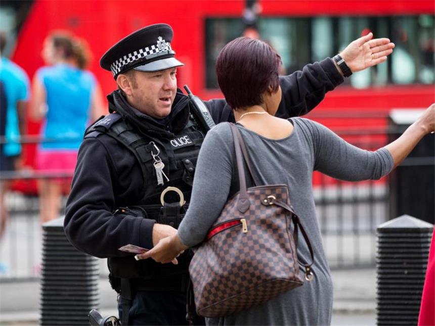 Nach London-Anschlag: Festnahme und Wohnungsdurchsuchung Eine Passantin holt sich in London bei einem Polizisten Rat. Großbritannien erhöht nach dem Bombenattentat die Terrorwarnung auf die höchste Stufe. Foto: Tom Nicholson / London News Pictures via ZUMA