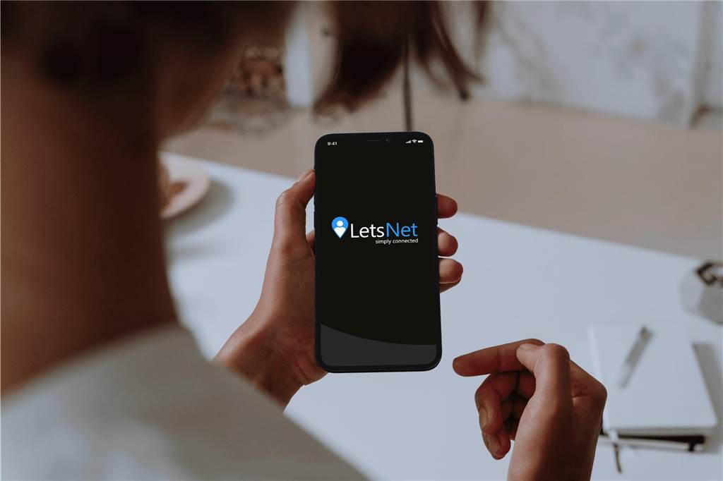 Gründer entwickeln App: Sie soll die Geschäftswelt verändern Eine Person hält ein Handy und öffnet die App "LetsNet".