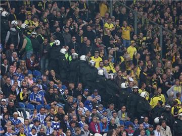 Eine Polizeikette trennt im Stadion die Fans von Schalke (l) und Dortmund. 