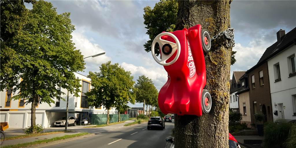 Rätselraten an Dorstener Bundesstraße: Bobby-Car am Baum festgekettet Eine stabile Kette hält das Bobby-Car an einem Baum, der an einer Dorstener Bundesstraße steht.