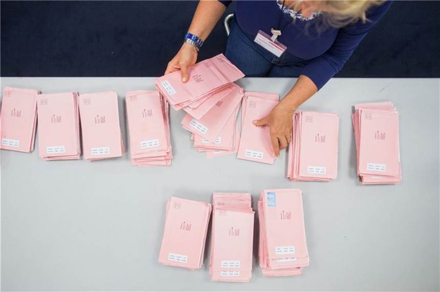Viele rote Umschläge: Hoher Briefwahlanteil in NRW erwartet Eine Wahlhelferin sortiert die roten Wahlbriefe mit den abgegebenen Stimmen.