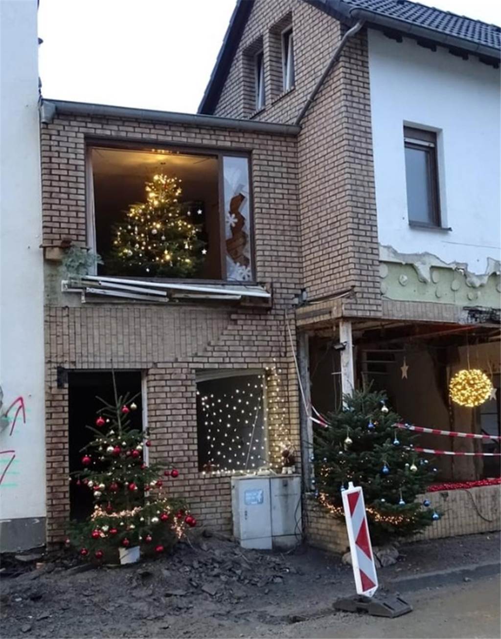 Familie Hawig fährt regelmäßig ins Ahrtal: „Viele Kämpfer kennengelernt“ Ein kaputtes Haus mit Weihnachtsbäumen im Fenster.