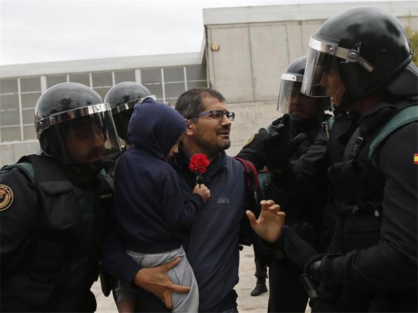 Hunderte Verletzte nach Gewalt bei Katalonien-Abstimmung Einheiten der Guardia Civil zwingen einen Mann mit Kind am Eingang eines Wahllokals umzukehren. Foto: Francisco Seco