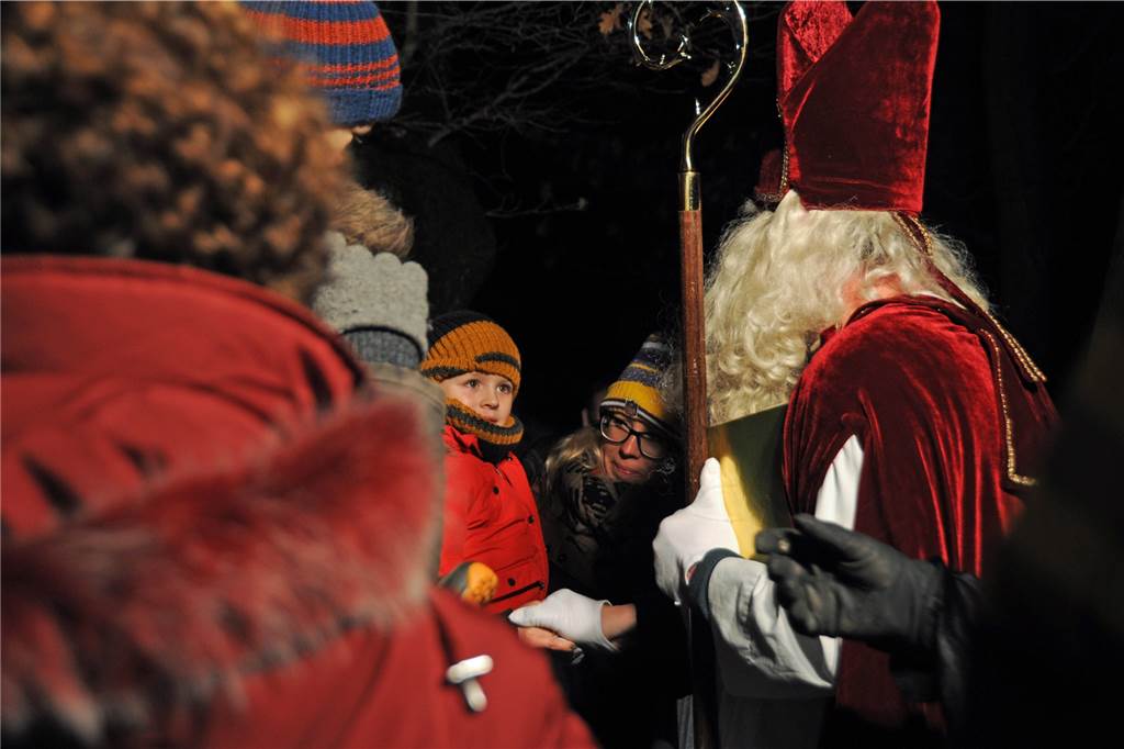 Der Nikolaus begrüßt die Kinder am Zaun