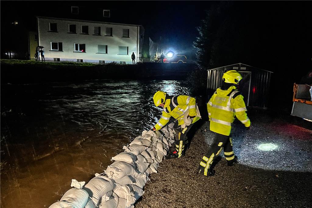 Nach Unwetter und Hochwasser in NRW : Jetzt kommt die Kälte Einsatzkräfte der Feuerwehr bauen einen Damm aus Sandsäcken zum Schutz vor dem Hochwasser.