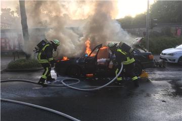 Einsatzkräfte löschen das brennde Fahrzeug.