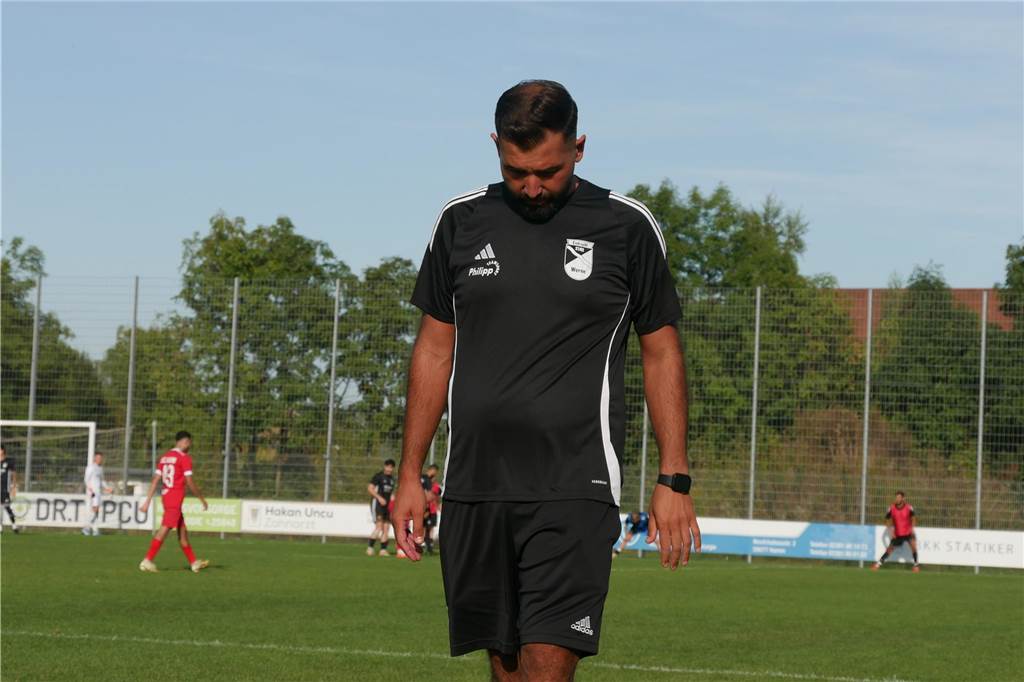 Vier Siege: Eintracht Werne will Heimserie gegen Uentrop fortsetzen Ein Mann mit schwarzem Poloshirt steht mit gesenktem Kopf am Seitenrand eines Spielfelds.