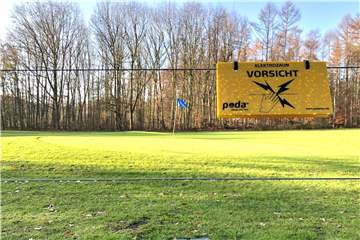 „Elektrozaun - Vorsicht": Am neuen Elektrozaun des Golfplatzes warnen Schilder vor den spannungsgeladenen Drähten.