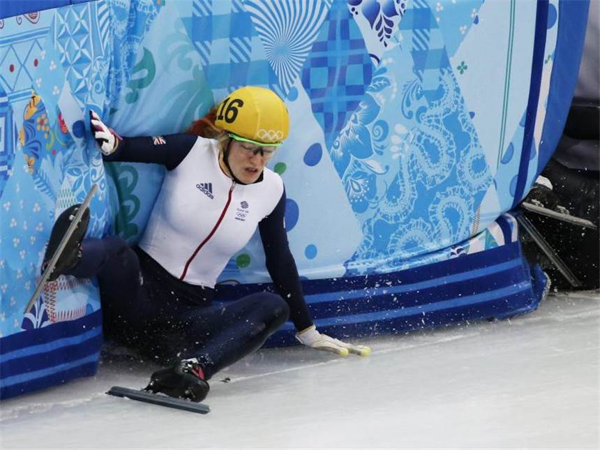 Li Jianrou holt Shorttrack-Gold für China Elise Christie landt nach ihrem Ausrutscher in der Bande. Foto: Barbara Walton