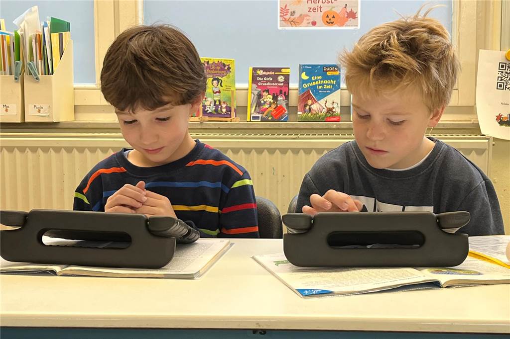 Schüler lernen individuell mit Tablets: Rat beschließt Neuanschaffung Zwei Schüler blicken auf ein Tablet.