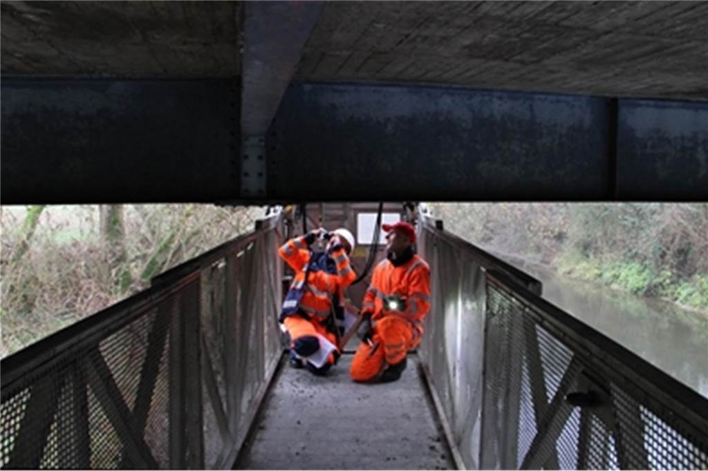 Lippe-Brücke in Vinnum wird für zwei Tage gesperrt Zwei Menschen kontrollieren ein Brückenbauwerk.
