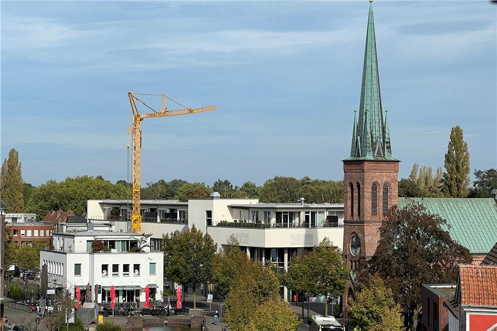 Großer Baukran verschwindet aus Innenstadt Ein großer Kran ragt über Hausdächer hinweg.