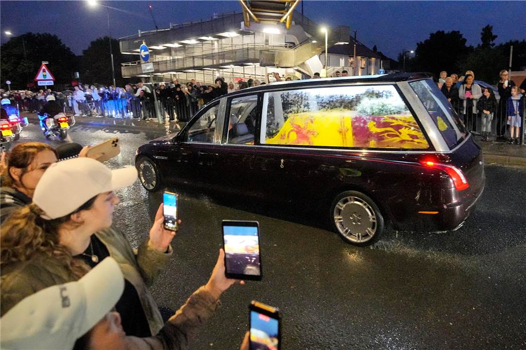 Menschen nehmen mit ihren Handys den Leichenwagen mit dem Sarg von Königin Elizabeth II. auf dem Weg zum Buckingham Palace auf.