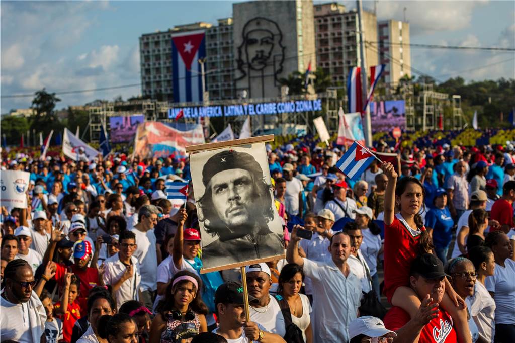 Er ist ein Mythos: Menschen marschieren mit Flaggen und einem Bild von Ernesto „Che“ Guevara bei der traditionellen Parade zum „Tag der Arbeit“ auf dem Revolutionsplatz in der kubanischen Hauptstadt Havanna.
