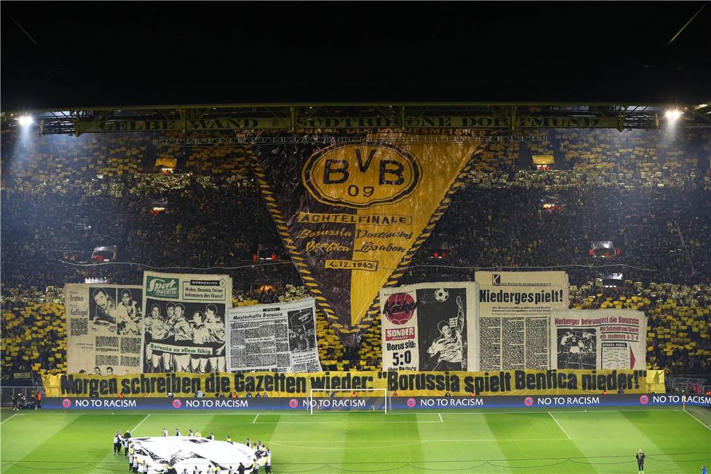 Es ist das Gedenken an das Jahrhundertspiel: Im Jahr 1963 holt Borussia Dortmund den Europapokal der Landesmeister gegen Benfica Lissabon. Im März 2017 gibt es die Neuauflage des Duells im Achtelfinale der Champions League. Passend zum Spielverlauf (der BVB gewann mit 4:0), kündigten die Fans in ihrer Choreo an: „Morgen schreiben die Gazetten wieder: Der BVB spielt Benfica nieder.“