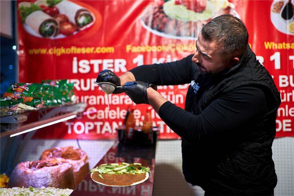 Außergewöhnliches Essen auf dem Festi Ramazan – sogar für Vegetarier? Eser Demivel drückt eine Zitrone über Salat und Cig Köfte aus.