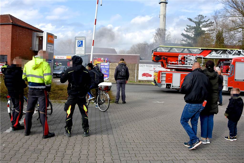 Etliche Schaulustige hatten sich schnell rund um das brennende Werkstattgebäude versammelt. Sie hielten allerdings den nötigen Abstand – so sahen es zumindest Feuerwehr und Polizei.