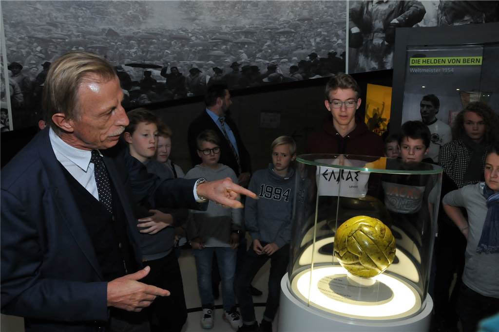 Warum Christoph Daum die Regensburger Domspatzen durch das Deutsche Fußballmuseum führte Ex-Startrainer vor Weltmeister-Ball: Christoph Daum erklärte seinen Zuhörern, wie schwer so ein Lederball bei Regen werden kann.