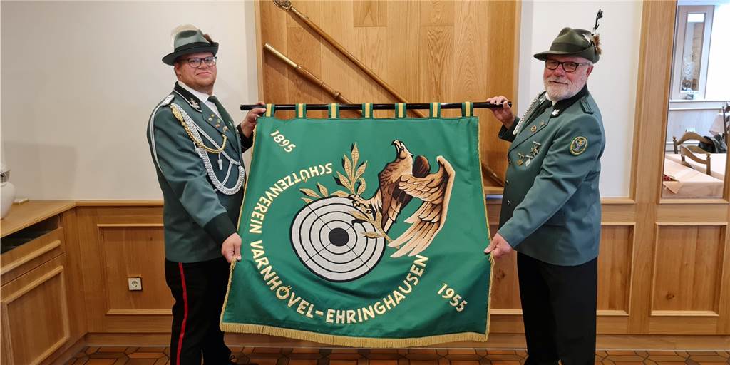 Fahnenwechsel bei Werner Schützenverein - neue Fahne mit besonderer Farbe Zwei Schützen mit einer Fahne.