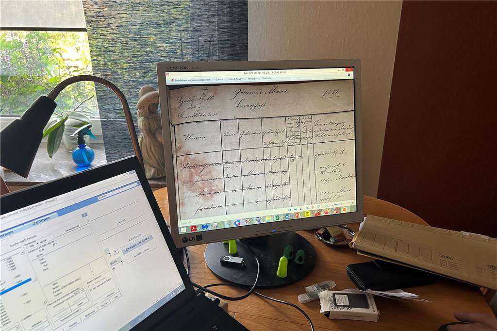 XXL-Abbild der Ahauser Bevölkerung entsteht Ein Bildschirm zeigt ein altes, digitalisiertes Dokument, daneben liegt eine Akte