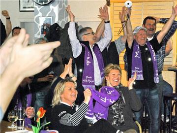 Fans und Familie von Maria Höfl-Riesch - in der Mitte Vater Siegfried - jubeln im Clublokal in Garmisch-Partenkirchen. Foto: Peter Lehner