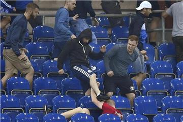 Fans vom FC Schalke 04 attackieren einen Anhänger von Eintracht Frankfurt. Foto: Martin Meissner/AP
