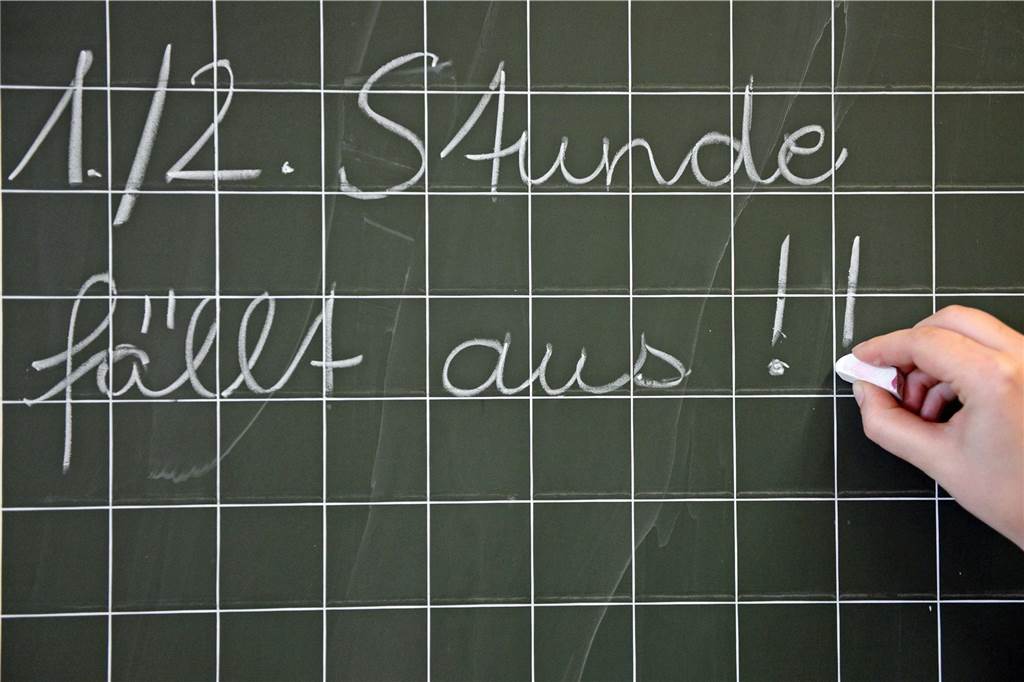 Eine Hand schreibt mit Kreise auf eine Tafel.
