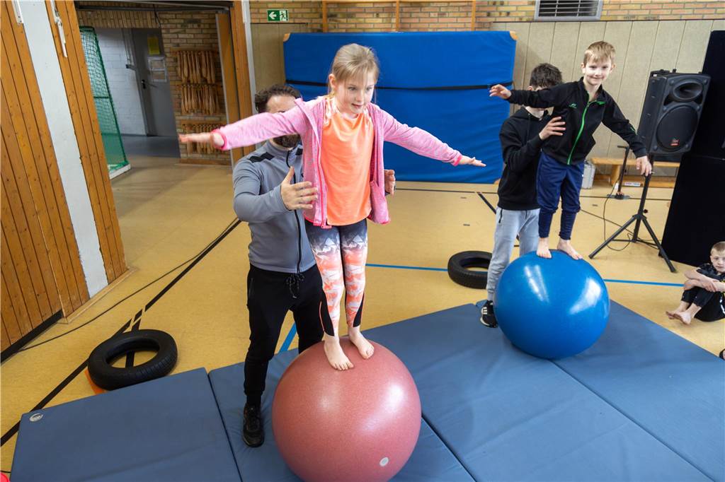 Kinder balancieren auf Gymnastikbällen.