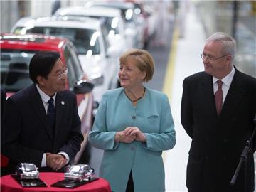 FAW-Vorsitzender Xu Jianyi (L)neben Kanzler Angela Merkel und VW-Chef Martin Winterkorn bei einem Rundgang durch die FAW-VW Fabrik in Chengdu. Foto: Kay Nietfeld/Archivbild