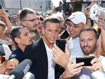 Federico Bernardeschi (M) wird vor seinem Medizincheck in Turin von Fans umringt. Foto: Allessandro Di Marco
