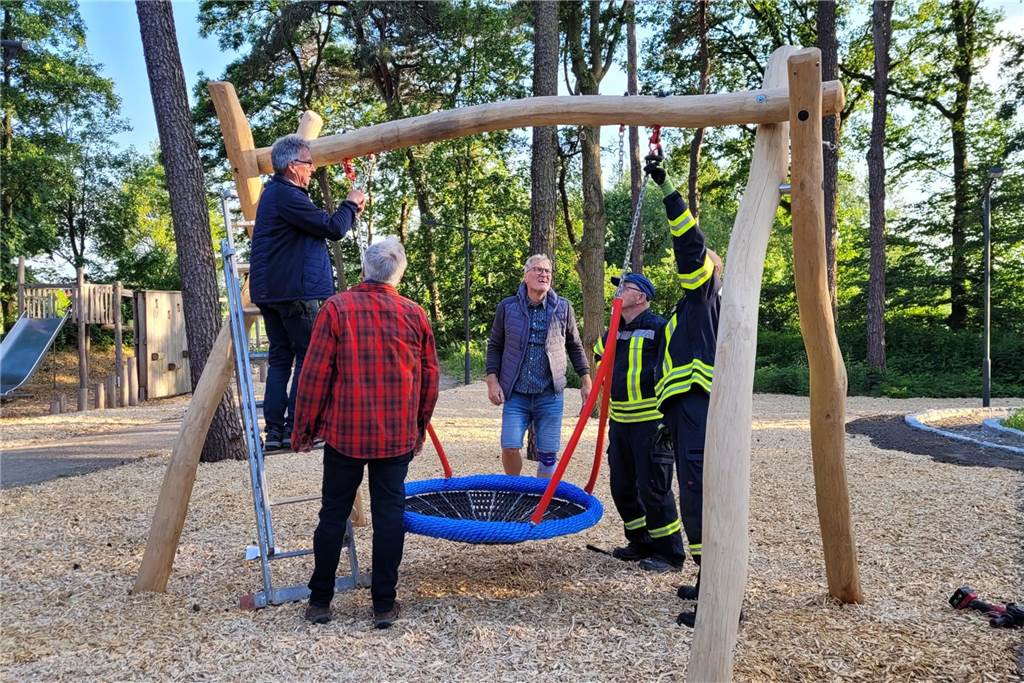 Männer hängen die neue Netzschaukel an der Reitanlage auf. 