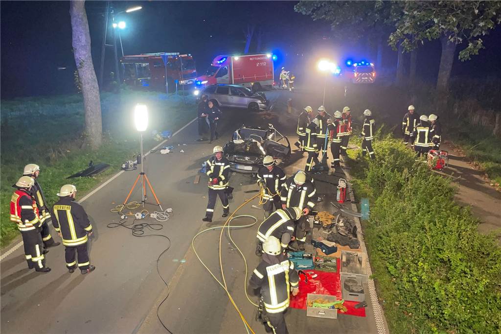 Schwerer Autounfall bei Goch: Frau 90 Minuten in Autowrack eingeklemmt Feuerwehrleute stehen um das Autowrack herum.