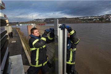 Feuerwehrleute bauen am Rheinufer eine mobile Hochwasserschutzmauer auf. Foto: Thomas Frey/Archiv