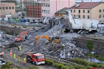 Feuerwehrleute entfernen Trümmer der teilweise eingestürzten Morandi-Autobahnbrücke in Genua. Foto: Luca Zennaro/ANSA