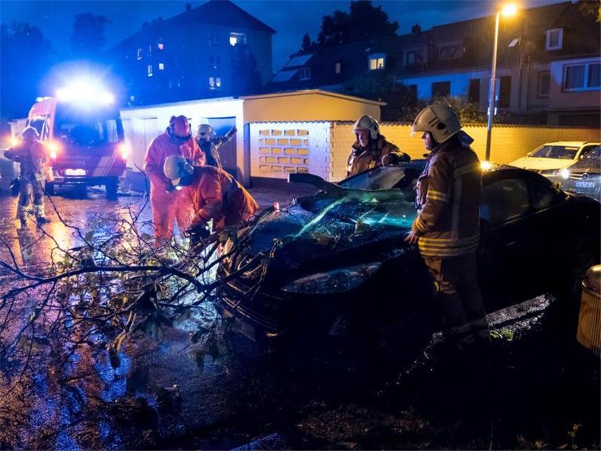So tobte das Unwetter über Deutschland Feuerwehrmänner schneiden nach einem schweren Unwetter in Hannover ein Fahrzeug unter einem Baum frei.