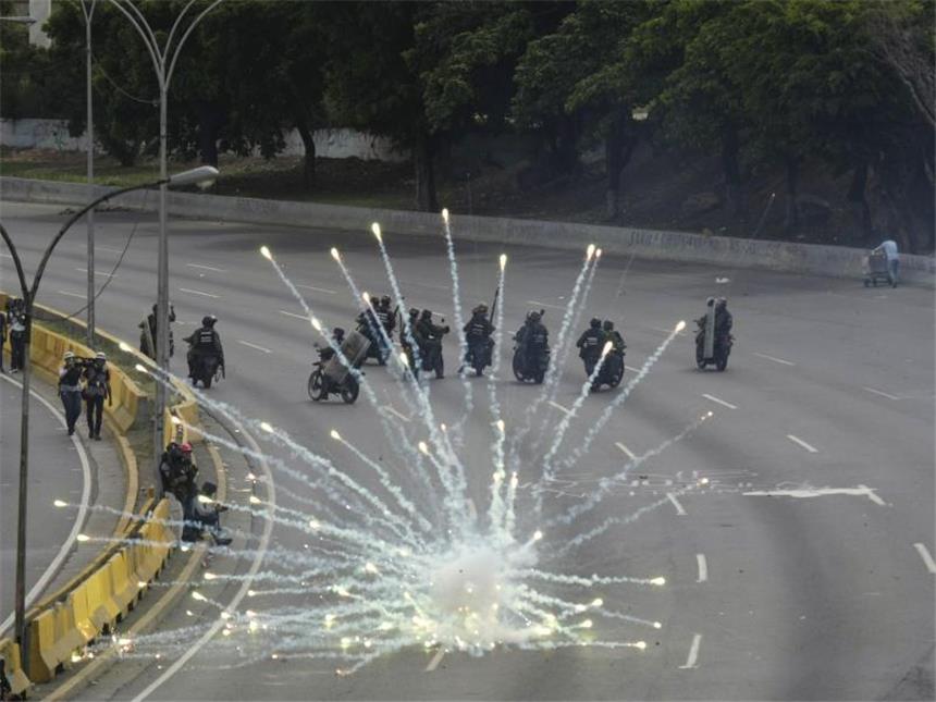 Blutige Proteste gegen die Regierung in Venezuela Feuerwerkskörper explodieren in der Nähe einer Gruppe von Sicherheitskräften. Foto: Fernando Llano