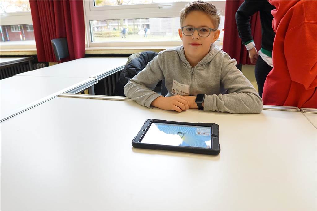 Finn erkärt den zukünftigen Schülern mit dem Tablet wie ein Stromkreislauf funktioniert.