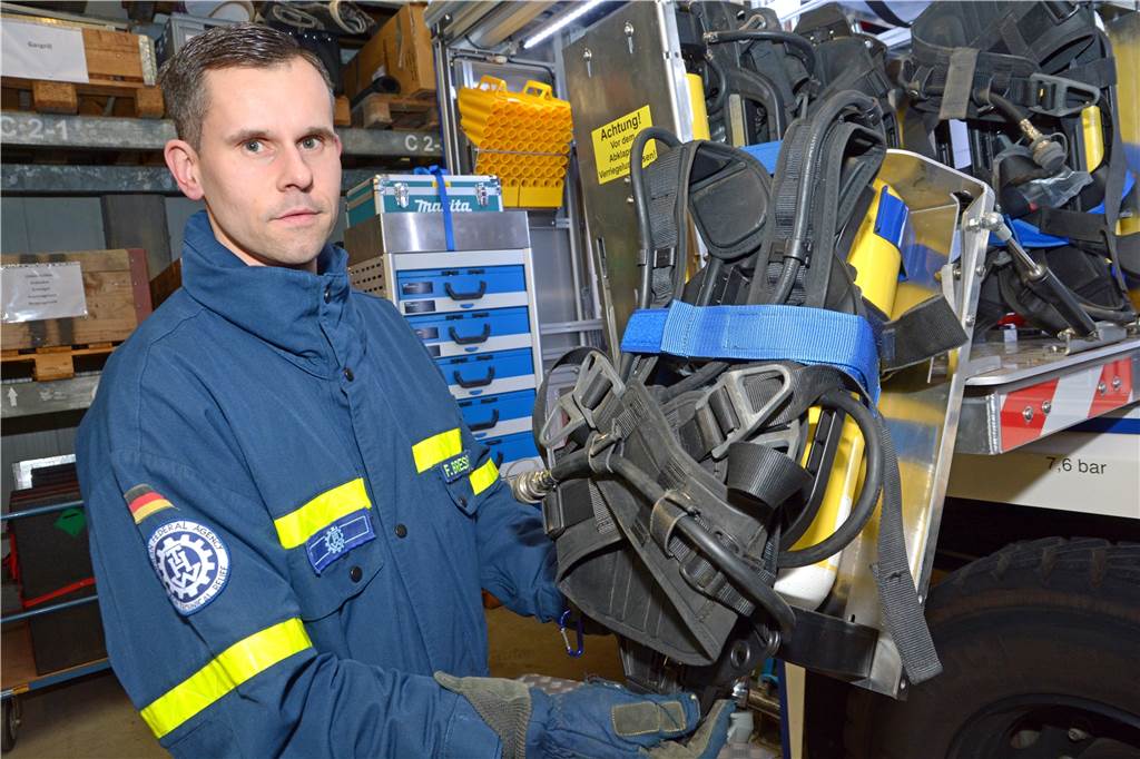 Florian Bressler holt eines der Atemschutzgeräte aus dem Wagen.
