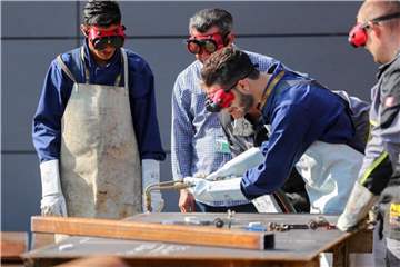 Flüchtlinge lernen in einem Industriebetrieb in Ingolstadt die Arbeit mit einem Schweißbrenner. Foto: Kay Nietfeld/Symbol