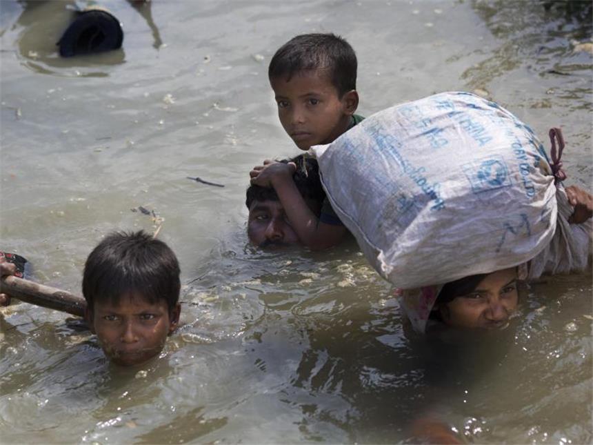 Massenflucht der Rohingyas alarmiert Hilfsorganisationen Flüchtlinge schwimmen durch einen Fluss nahe Cox's Bazar und erreichen die Grenze zu Bangladesch. Auch dort sind sie aber im Grunde unerwünscht. Foto: Bernat Armangue