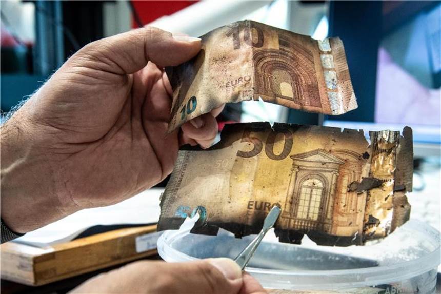 Puzzeln mit Scheinen - Zentrum für beschädigtes Geld Frank Herzog, Sachverständiger für beschädigtes Bargeld, hält im Nationalen Analysezentrum der Bundesbank eine 10-Euro- sowie 50-Euro- Banknote. Foto: Silas Stein