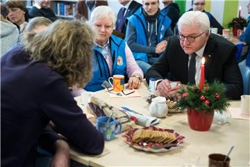 Frank-Walter Steinmeier (r) unterhält sich mit Mitarbeitern und Obdachlosen. Foto: Bernd von Jutrczenka