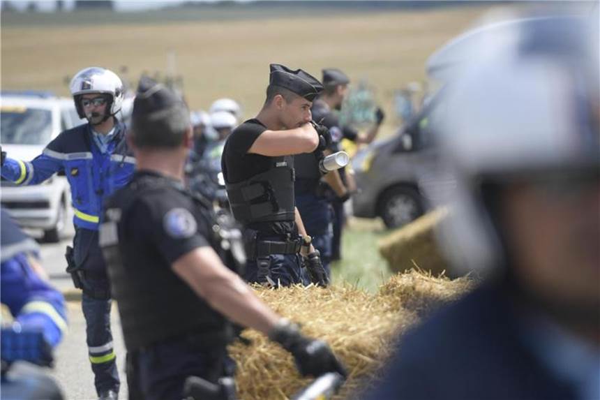 Größte Sport-Arena der Welt: Tour-Sicherheit heikles Thema Französische Polizisten greifen während der 16. Tour-Etappe zu Pfefferspray. Foto: Yorick Jansens/BELGA